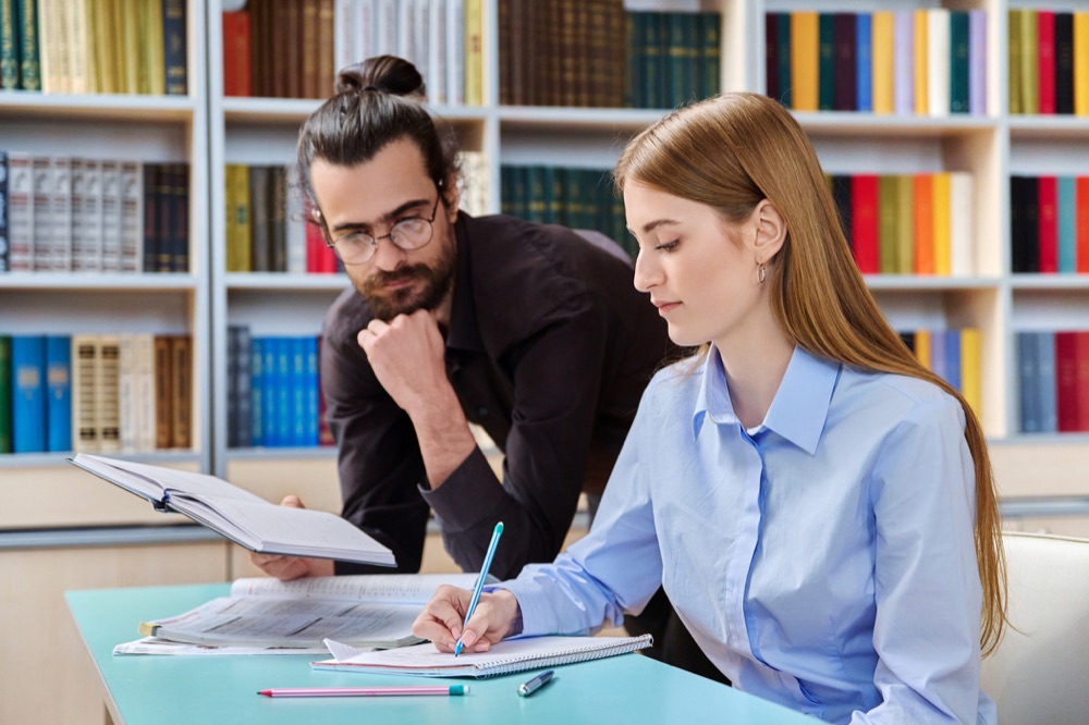 Zwei Schüler lernen gemeinsam in der Bibliothek